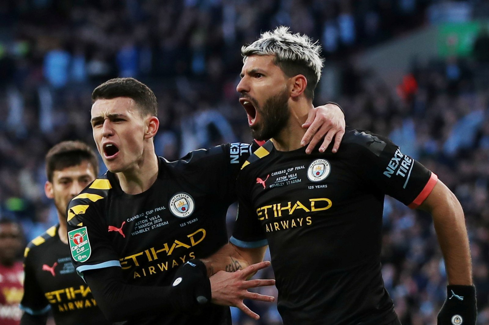 Manchester City's Sergio Aguero (R) and Phil Foden celebrate scoring their first goal against Aston Villa in London, March 1, 2020. (Reuters Photo)