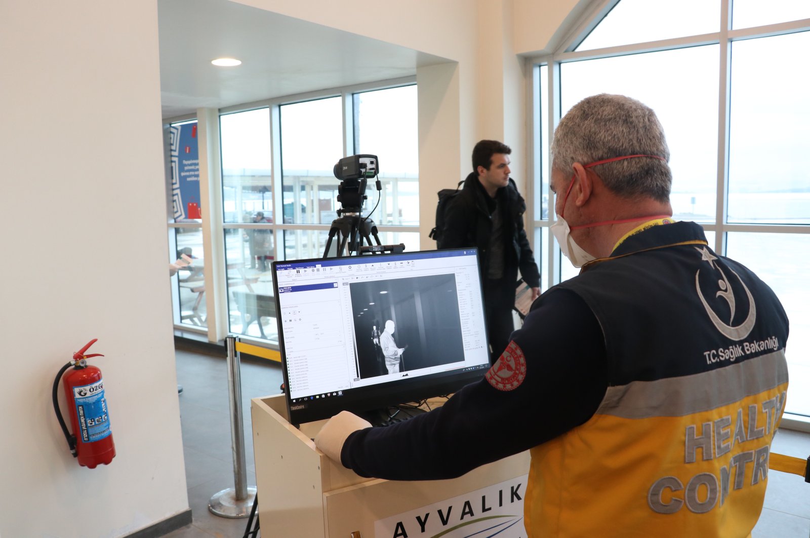 A Health Ministry worker uses a thermal scanner to monitor tourists arriving from Greece, Balıkesir, Mar. 5, 2020. (AA Photo) 
