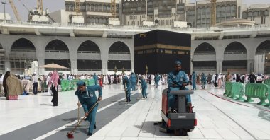 Workers clean the Grand Mosque, during the minor pilgrimage, known as Umrah, in the Muslim holy city of Mecca, Saudi Arabia, March 2, 2020. (AP Photo)