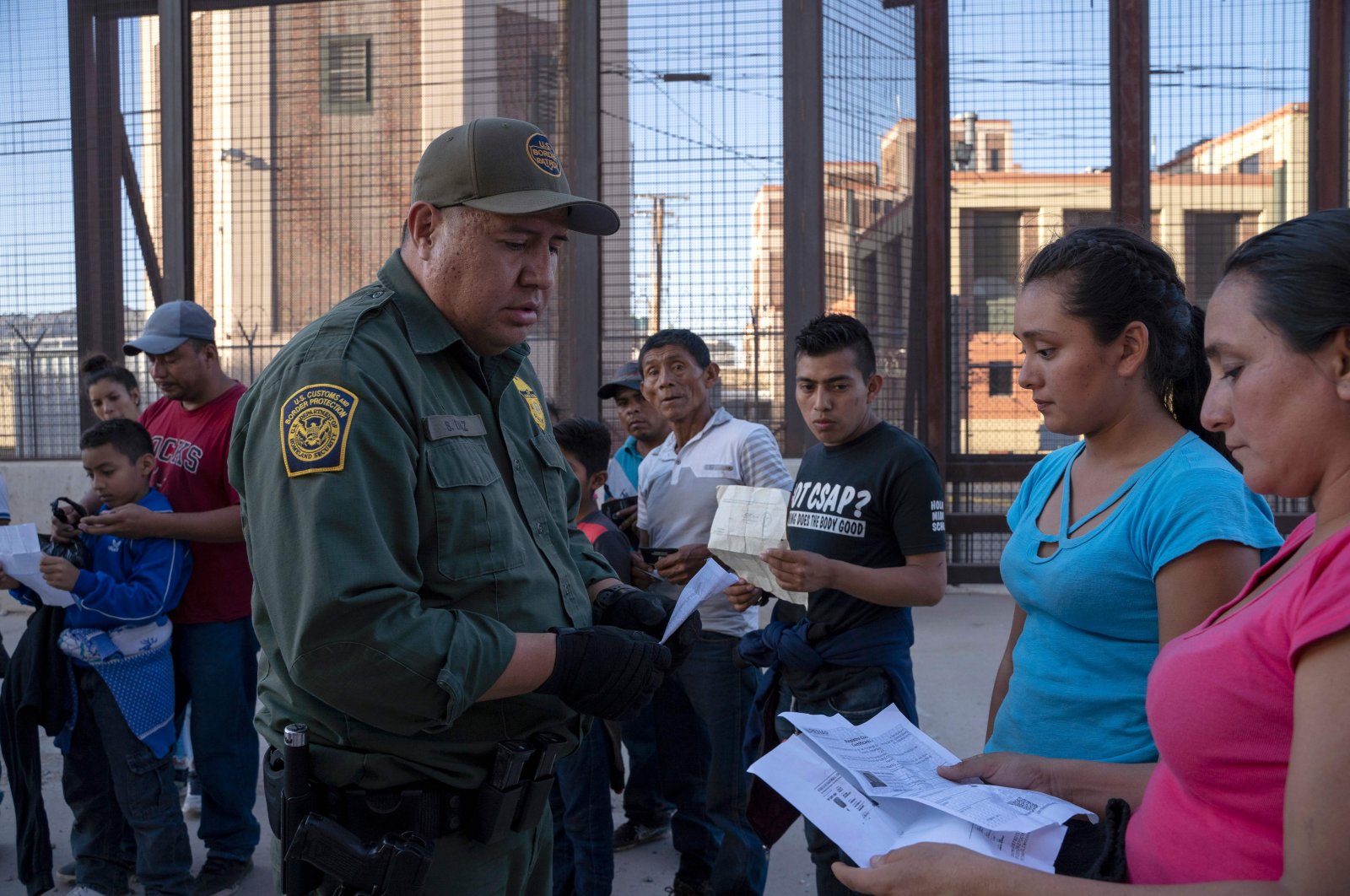 In this file photo taken on May 16, 2019, U.S. Customs and Border Protection agent checks documents of a small group of migrants, who crossed the Rio Grande from Juarez, Mexico, in El Paso, Texas. (AFP)