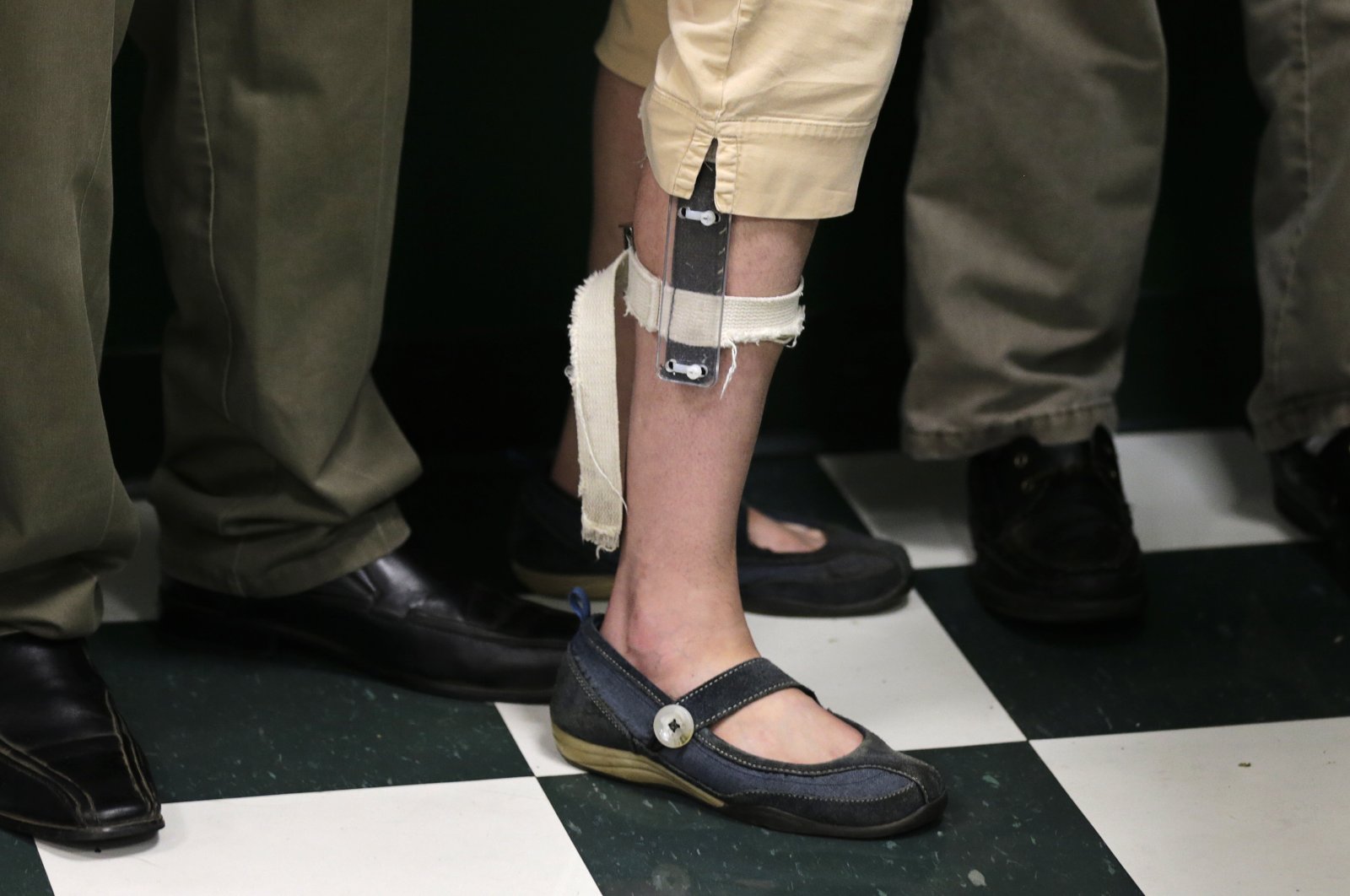 In this Aug. 13, 2014 photo, a female student wearing a shocking device on her leg lines up with classmates after lunch at the Judge Rotenberg Educational Center in Canton, Mass. (AP Photo)