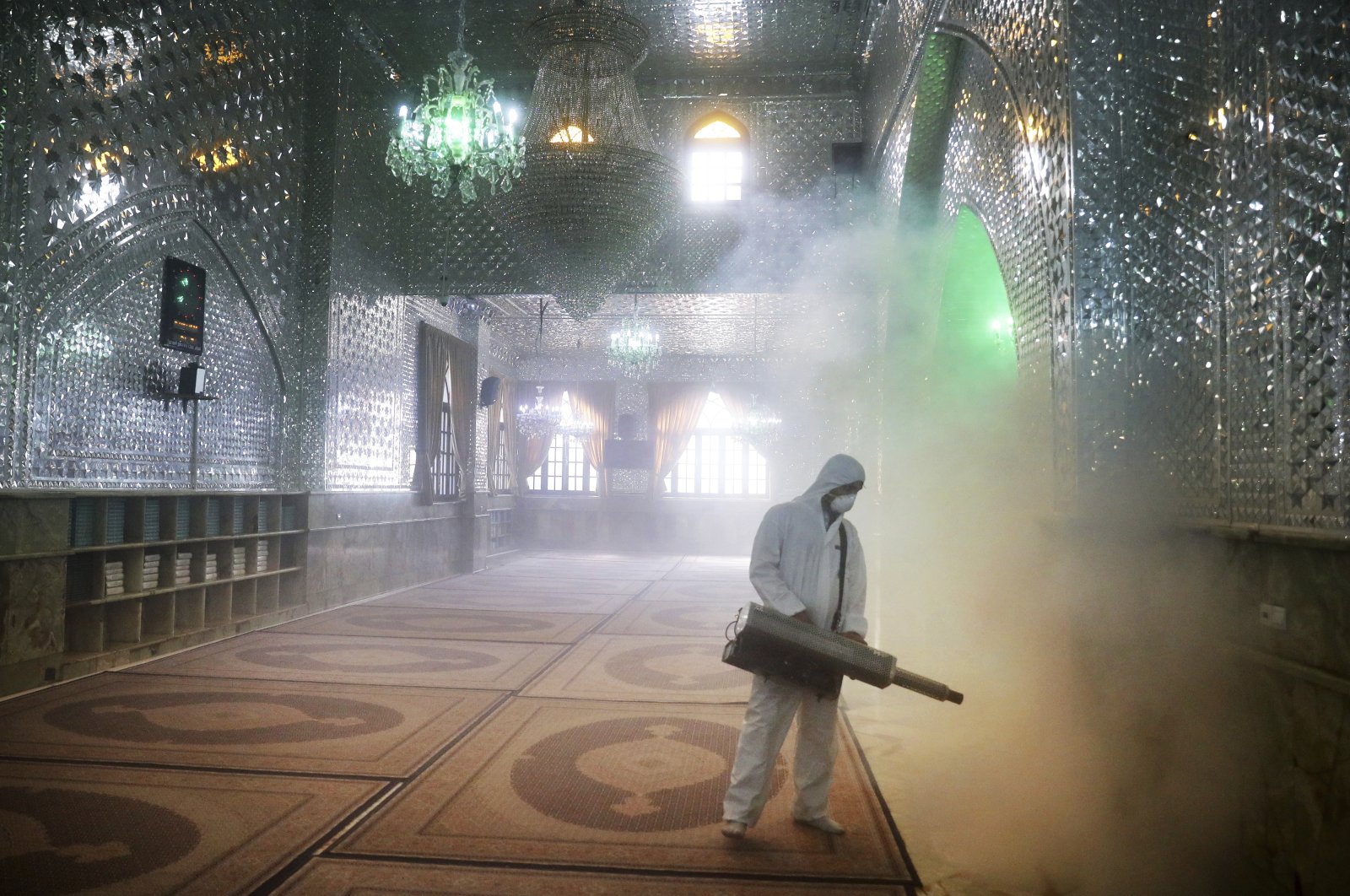 A firefighter disinfects the shrine of Saint Saleh to help prevent the spread of the new coronavirus in northern Tehran, Iran, Friday, March, 6, 2020. (AP Photo)