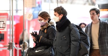 Passengers wearing protective face masks enter Milano Centrale railway station in Milan on March 8, 2020. (AFP Photo)