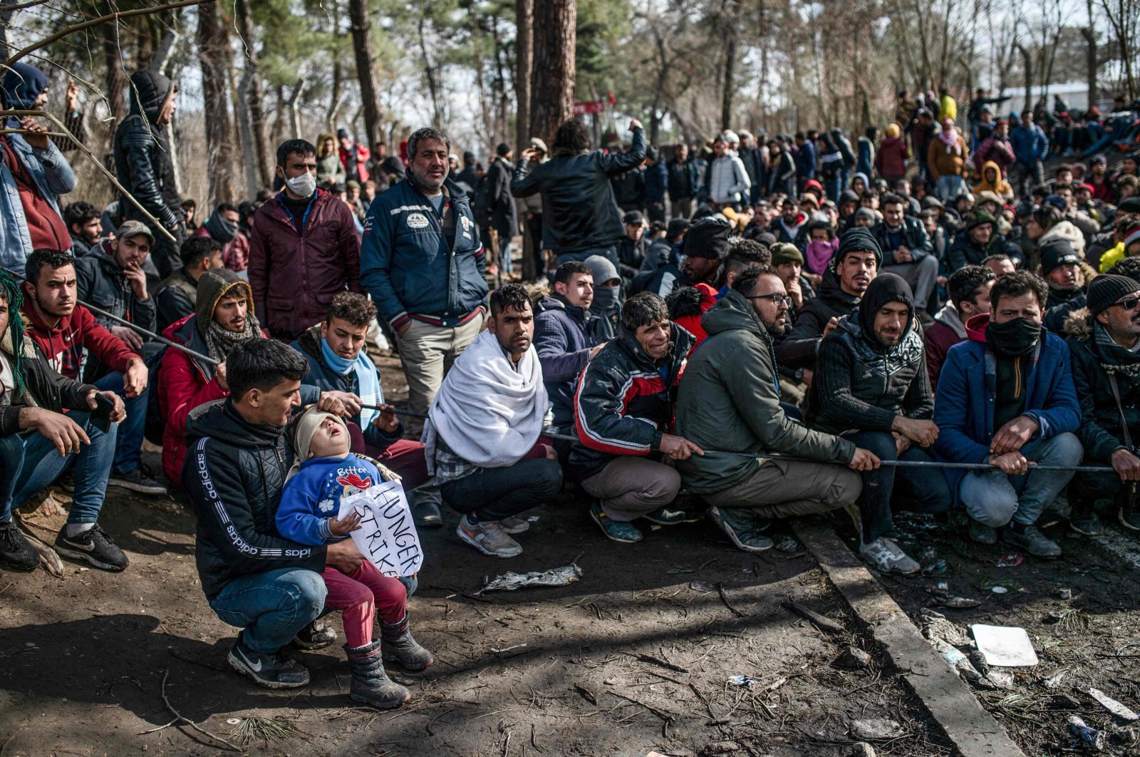 Migrants wait with their children in the buffer zone at the Turkey-Greece border near the Pazarkule crossing gate in Edirne, Mar. 5, 2020. (AFP Photo)