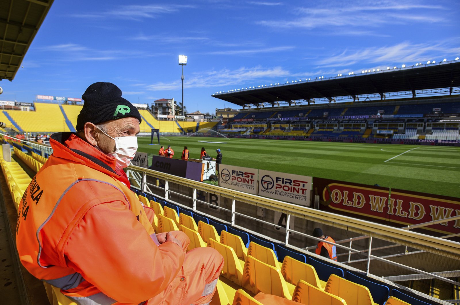 A man with a mask sits in the stands ahead of a Serie A match between Parma and Spal, March 8, 2020. (AP Photo)