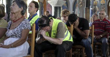 Orthodox faithful attend a memorial service for the victims of a forest fire, inside a church at Mati village, east of Athens, July 29, 2018. (AP Photo)