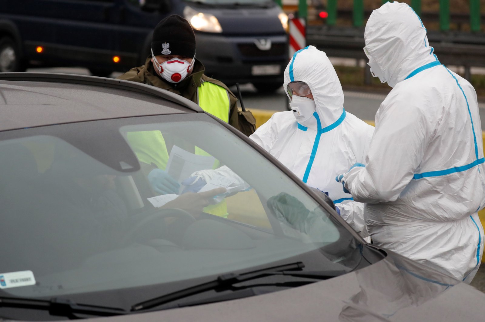 Medical staff with protective clothing perform checks on drivers at Jedrzychowice border crossing, between Poland and Germany, March 9, 2020. (AFP Photo)