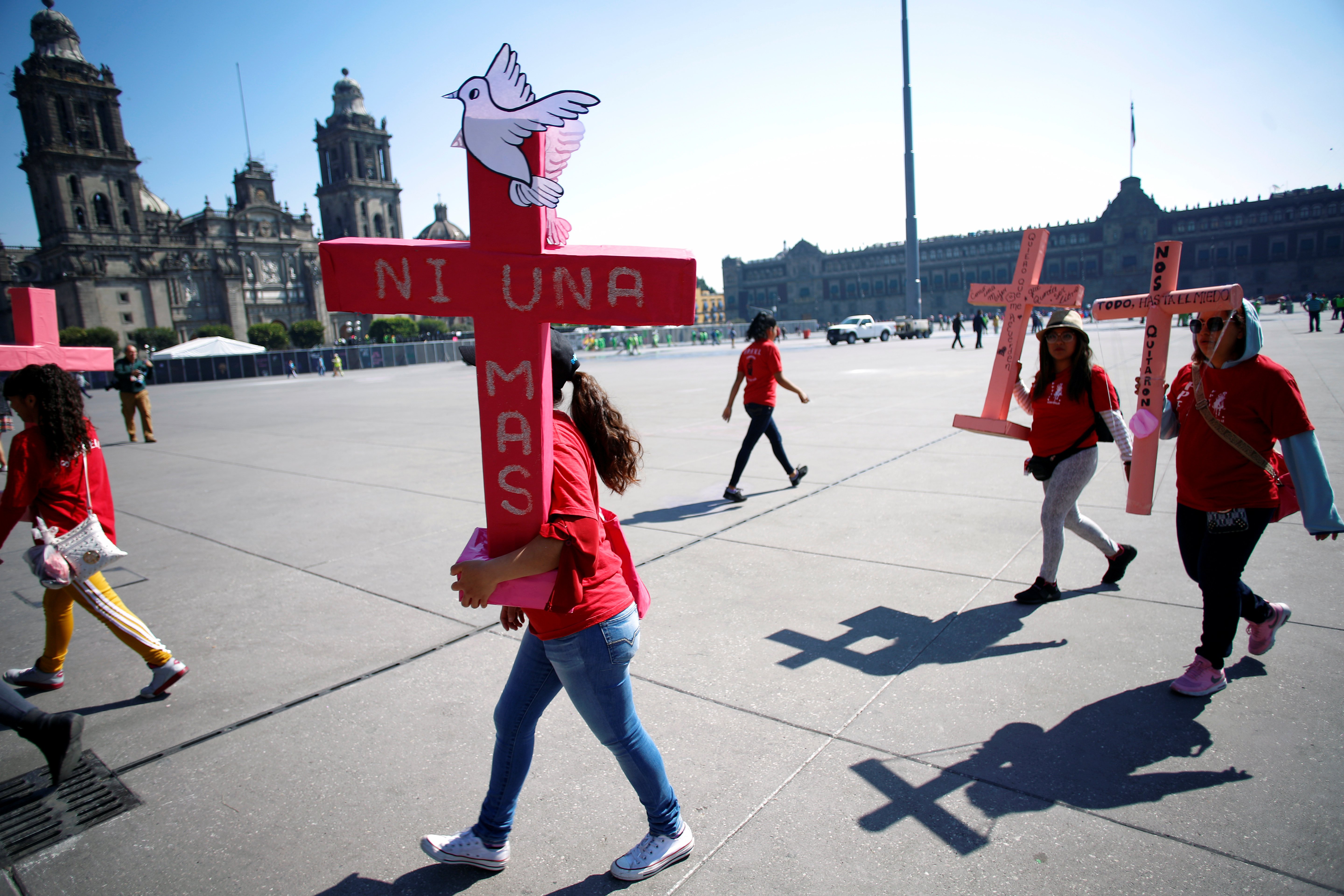 Women carry pink crosses during 
