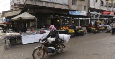 Man rides a motorcycle through a market in the city of Idlib during the ceasefire, March 9, 2020. (AP Photo)