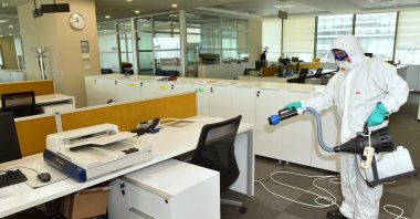 A man seen with a disinfection equippment in an office in Turkey. (IHA Photo)