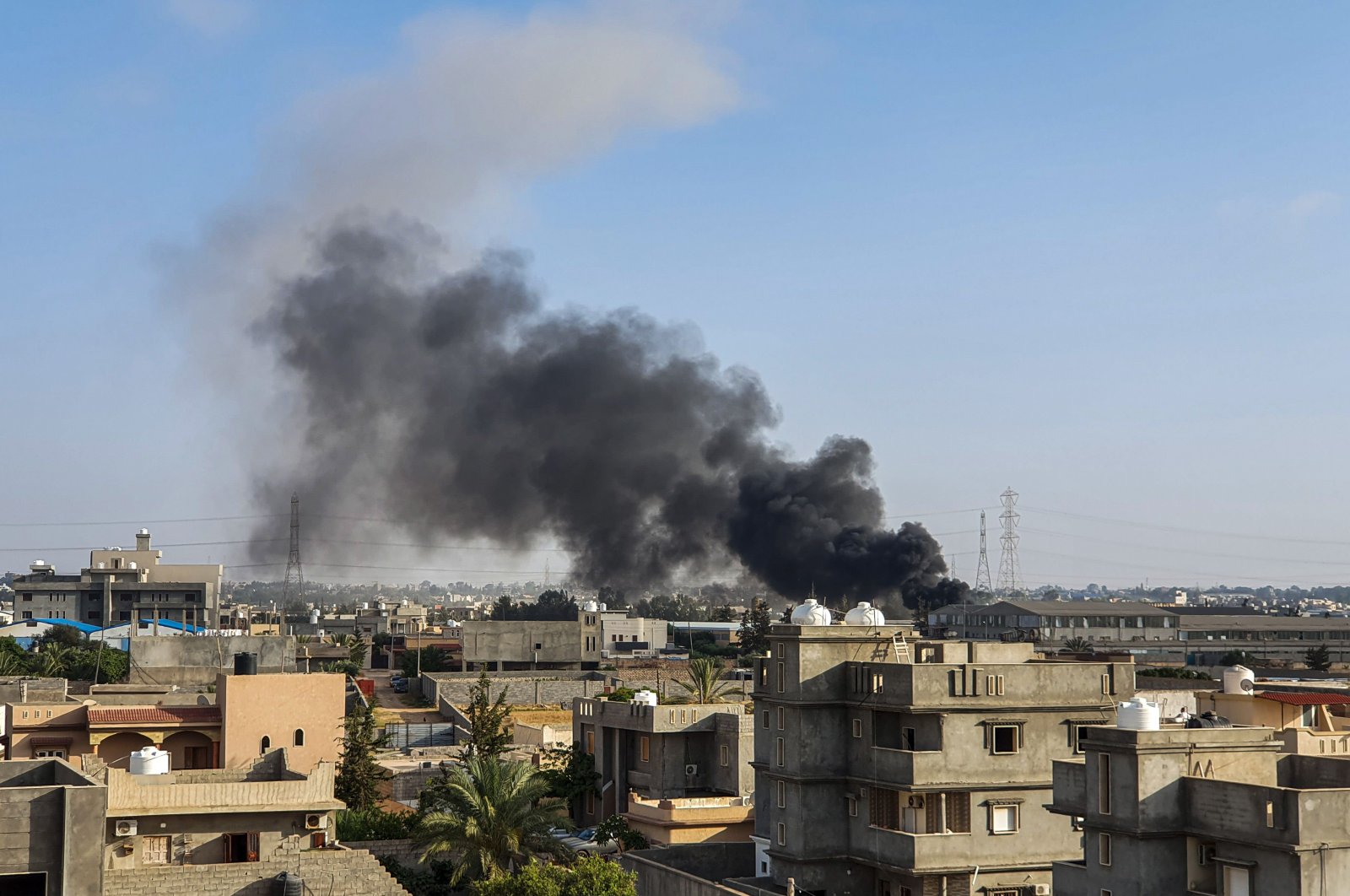 This picture taken on June 29, 2019, shows smoke plumes rising in Tajoura, south of the Libyan capital Tripoli, following a reported airstrike by forces loyal to putschist Gen. Khalifa Haftar. (AFP Photo)