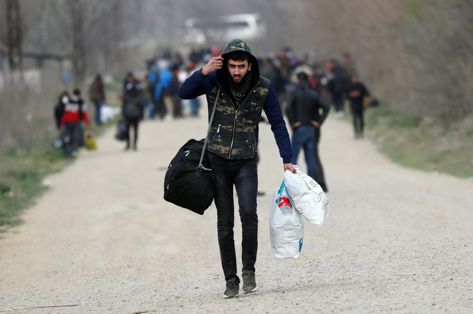 A migrant walks near Turkey's Pazarkule border crossing with Greece's Kastanies, in Edirne, March 10, 2020. REUTERS