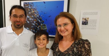 Tolga (L), Ömer Ege (C) and Bahar Taymaz (R) pose in front of one of the many underwater photos they have taken. (All photos courtesy of Tolga Taymaz)