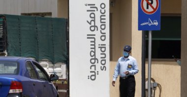 A security guard wears a mask as he checks vehicles entering a compound for Saudi Aramco, Jeddah, March 9, 2020. (AP Photo)