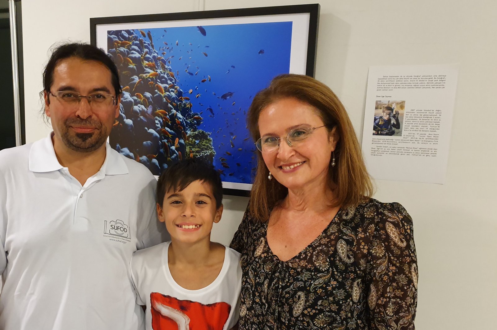 Tolga (L), Ömer Ege (C) and Bahar Taymaz (R) pose in front of one of the many underwater photos they have taken. (All photos courtesy of Tolga Taymaz)