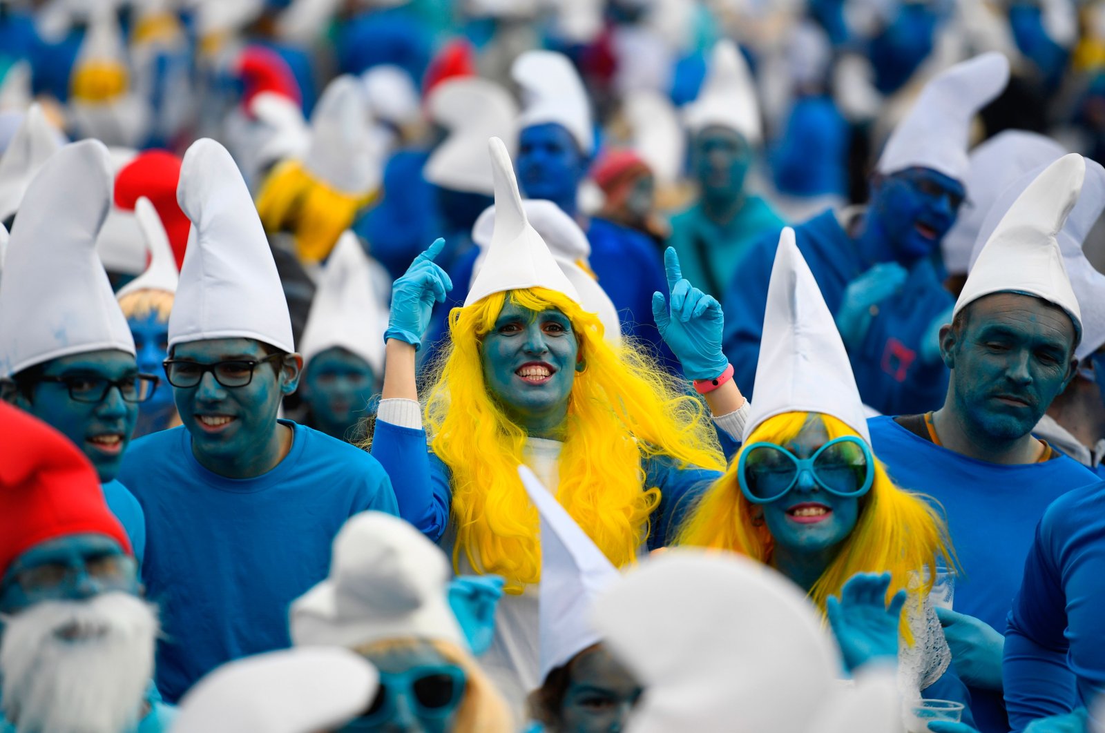 People dressed as Smurfs, a Belgian comic franchise centered on a fictional colony of small, blue, human-like creatures who live in mushroom-shaped houses in the forest, attend a world-record gathering of Smurfs on March 7, 2020, in Landerneau, western France. (AFP Photo)