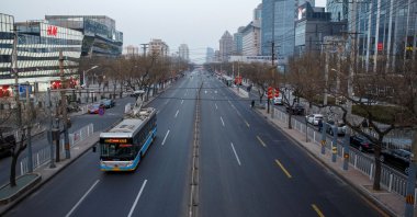 An electric bus goes on a usually busy main road in the Sanlitun shopping district in Beijing, China, Feb. 4, 2019. (Reuters Photo)