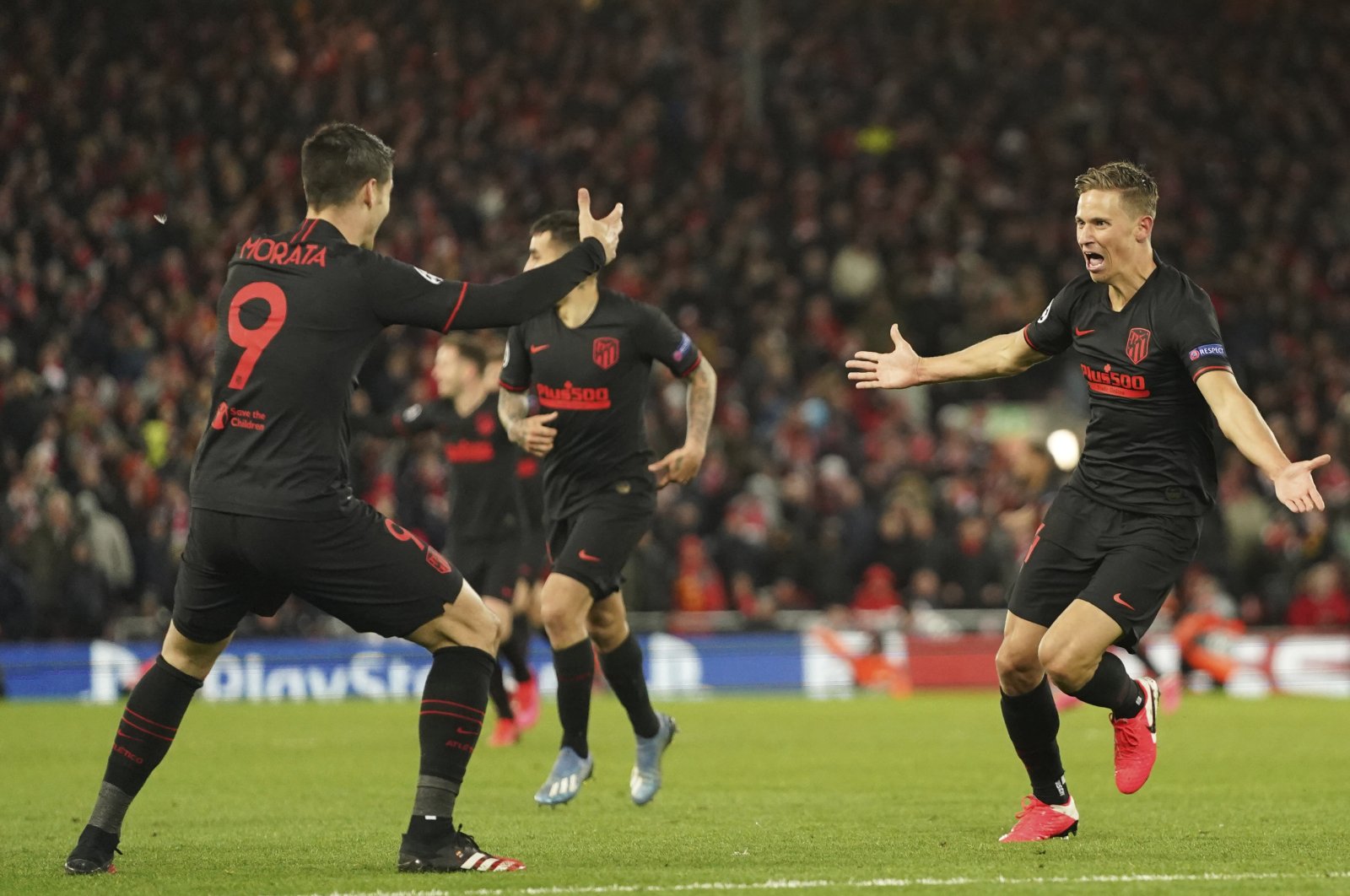 Atletico Madrid's Marcos Llorente, right, celebrates after scoring his side's second goal during a second leg, round of 16, Champions League soccer match between Liverpool and Atletico Madrid at Anfield stadium in Liverpool, England, Wednesday, March 11, 2020. (AP Photo)