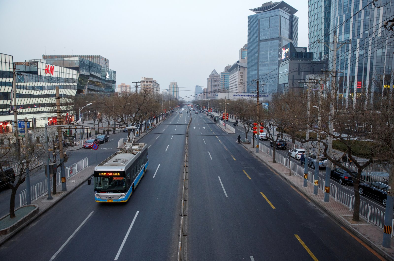 An electric bus goes on a usually busy main road in the Sanlitun shopping district in Beijing, China, Feb. 4, 2019. (Reuters Photo)