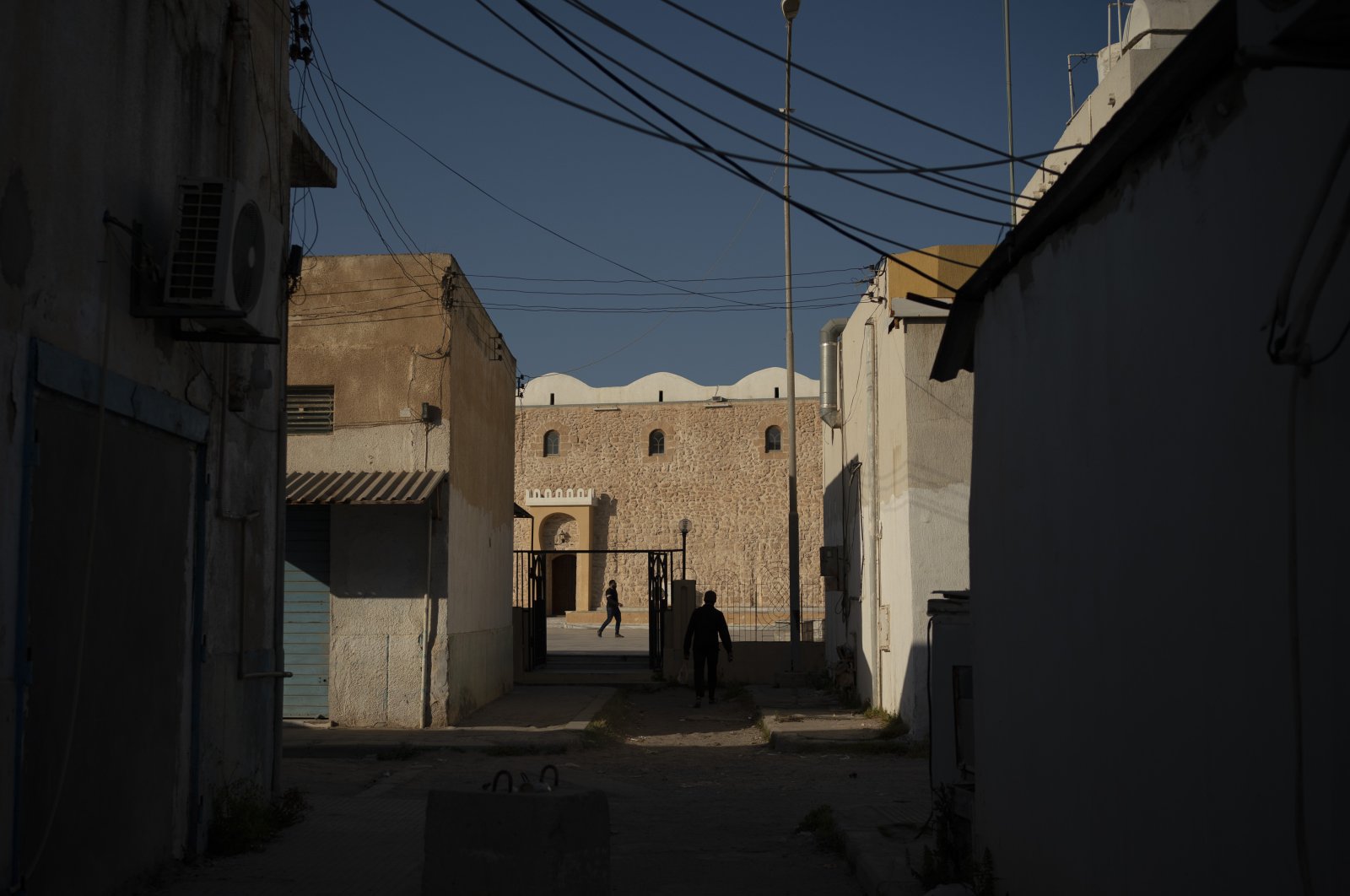 People walk outside a mosque in Tripoli, Libya, on Feb. 27, 2020. Eastern-based Haftar forces attacked Tripoli last spring to wrest it from control of the U.N.-backed government. (AP Photo)