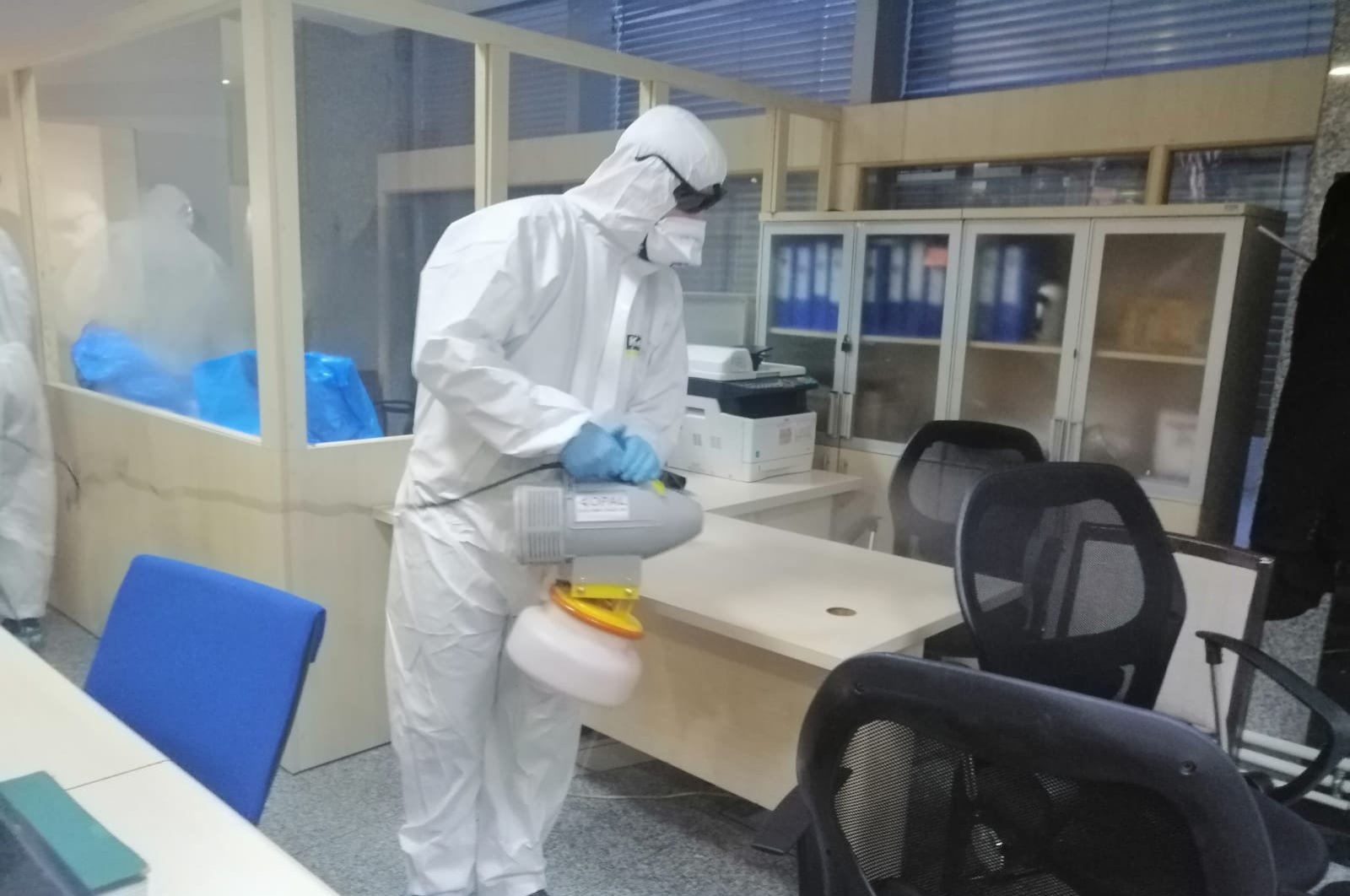 An employee in a protective uniform disinfects an office at the Turkish Parliament, March 11, 2020. (DHA)