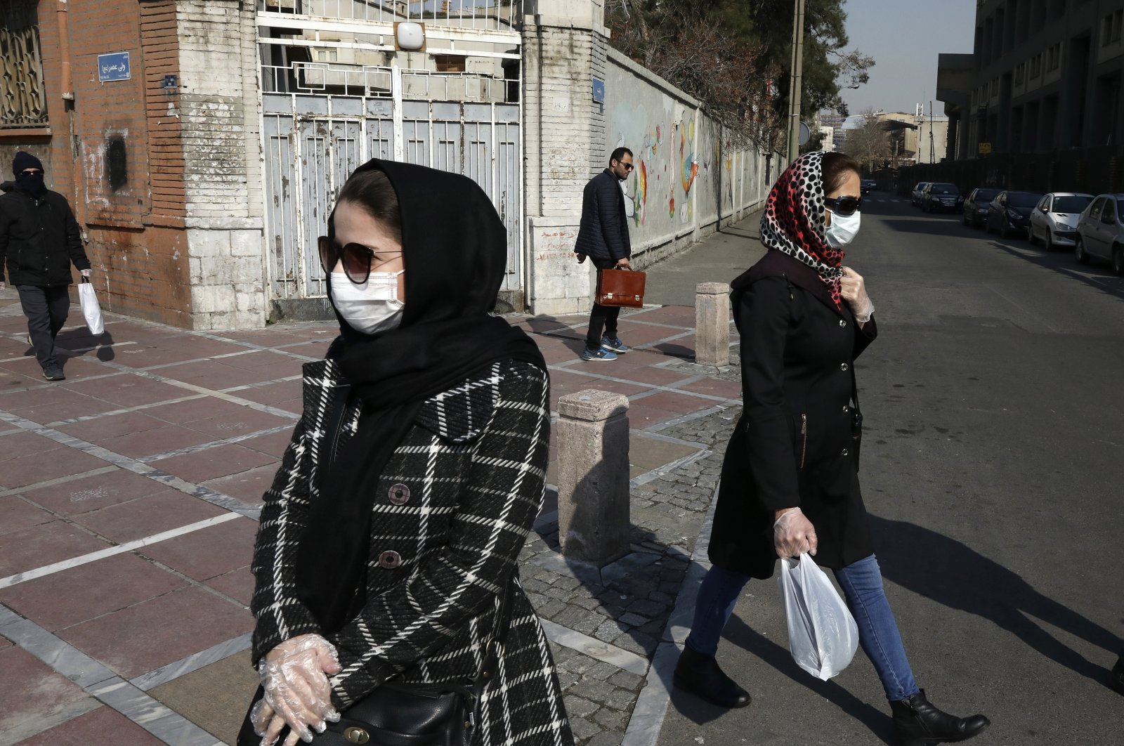 Pedestrians walk as some of them wear masks in downtown Tehran, Iran, Feb. 27, 2020. (AP Photo)