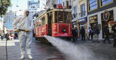 A worker spray disinfectants at famed İstiklal Avenue, Istanbul, March 13, 2020. (AA Photo)
