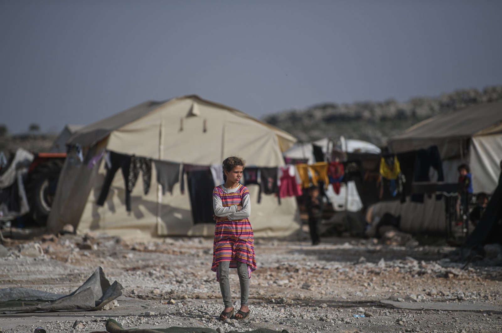 A displaced Syrian girl looks on at a makeshift camp in Kafr Lusin village on the border with Turkey in Syria's northwestern province of Idlib, Tuesday, March 10, 2020. (AFP Photo)