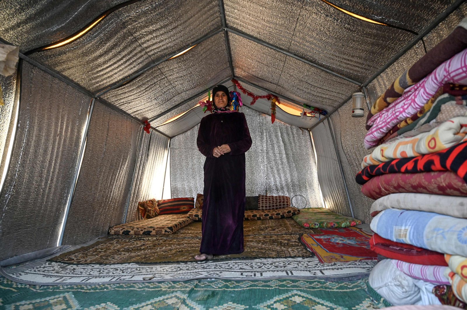 Noora al-Ali, ais pictured in her new concrete home at a camp created by Turkey's Humanitarian Relief Foundation (IHH) near Kafr Lusin on the border with Turkey in Syria's northwestern province of Idlib, March 10, 2020. (AFP)