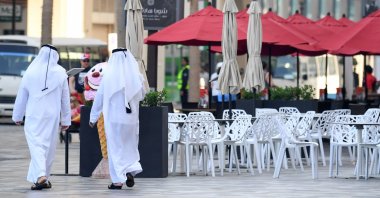 Emirati men walk along the empty beachside boulevard of Jumeirah Beach Residence which is usually crowded, in the Gulf emirate of Dubai on March 12, 2020. (AFP Photo)