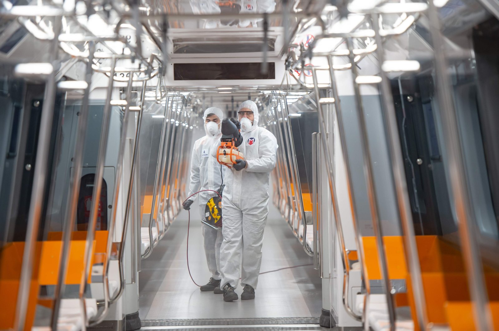 Employees of the Istanbul Municipality wearing protective gear disinfects a subway carriage to prevent the spread of the COVID-19 in Istanbul, March 12, 2020. (AFP Photo)