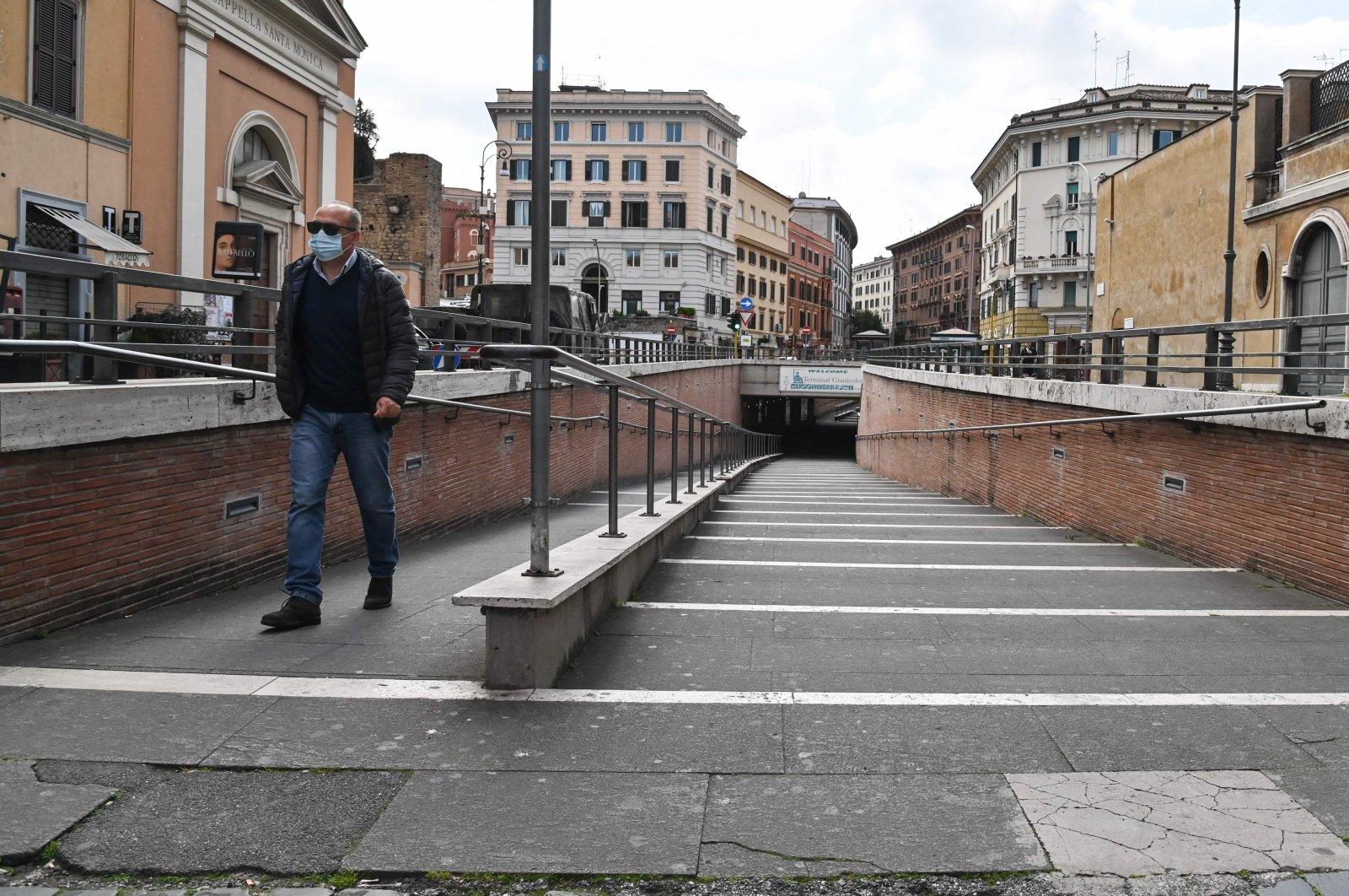 A person wearing a respiratory mask walks across a deserted Vatican underpass near ST. Peter Basilica, in central Rome, March 15, 2020. (AFP Photo)