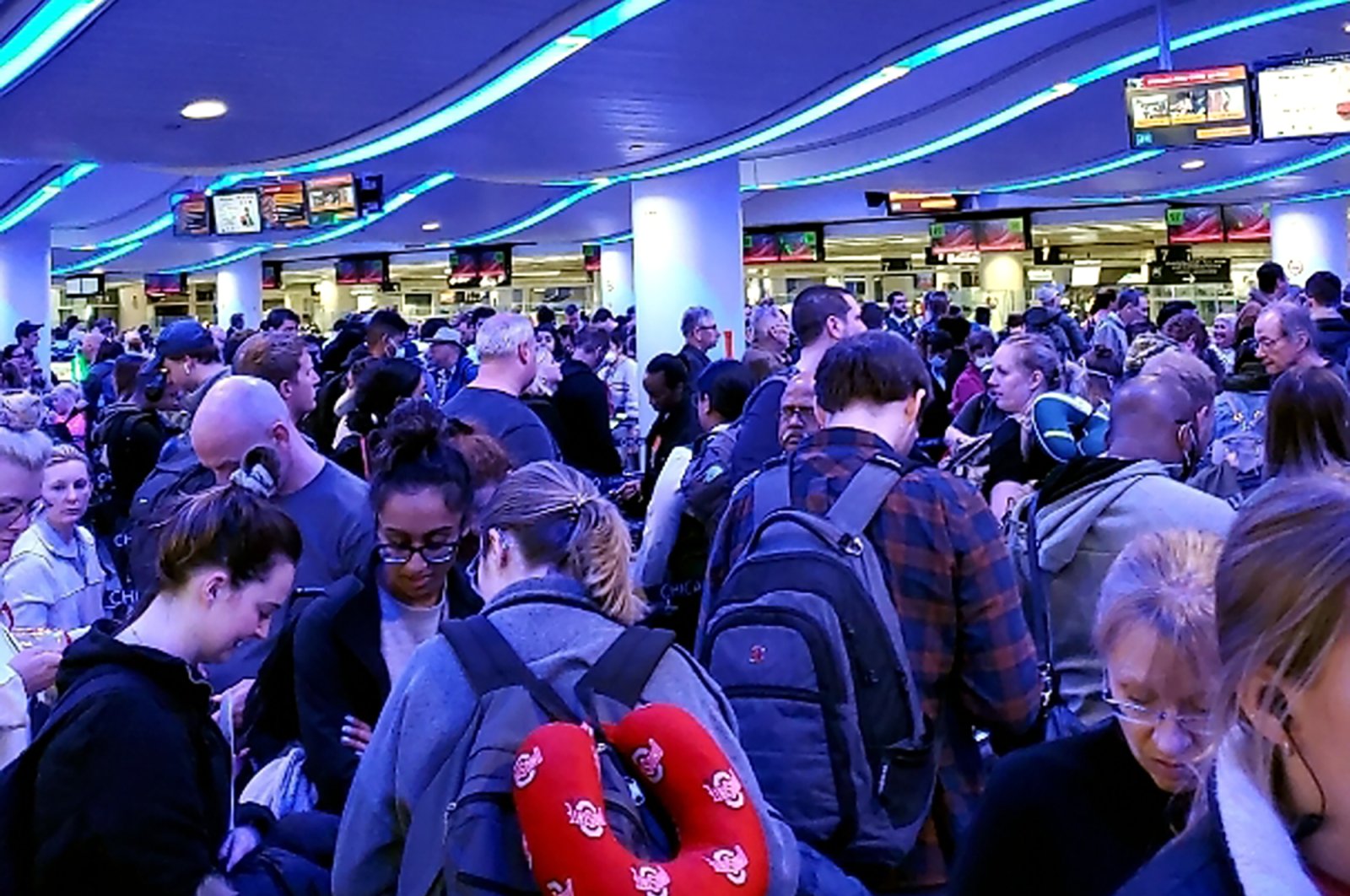 In this Saturday, March 14, 2020 photo provided by Elizabeth Pulvermacher, travelers returning from Madrid wait in a coronavirus screening line at Chicago's O'Hare International Airport. (Elizabeth Pulvermacher via AP)