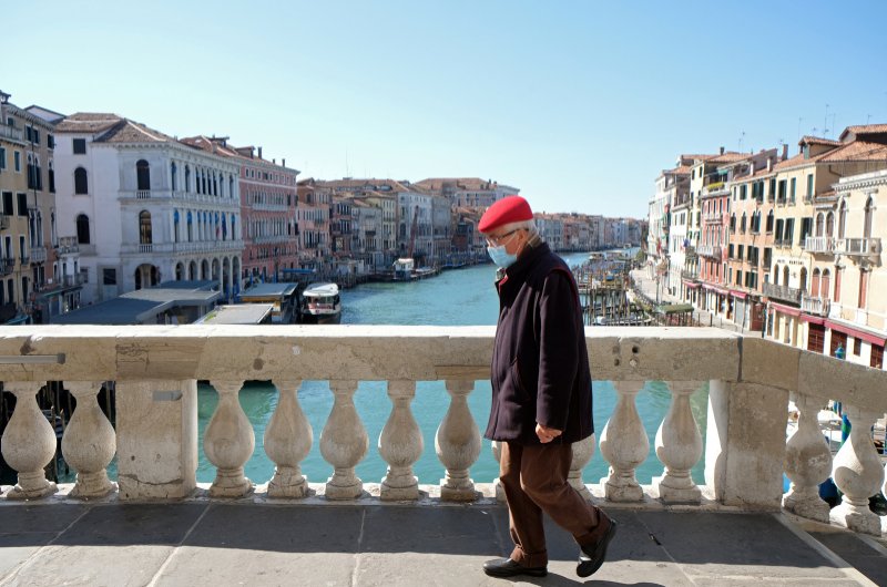 A man wearing a protective mask on an empty Rialto Bridge on Sunday with an unprecedented lockdown across of all Italy imposed to slow the outbreak of coronavirus, in Venice, Italy, March 15, 2020. (Reuters Photo)