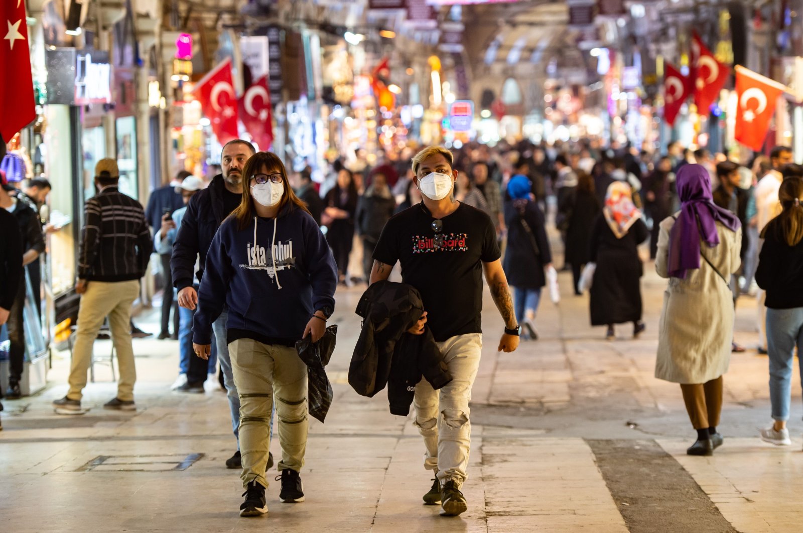 A woman and a man wearing face masks walk in Istanbul's historic Grand Bazaar, one of the city's main tourist attractions, March 13, 2020. (AFP Photo)