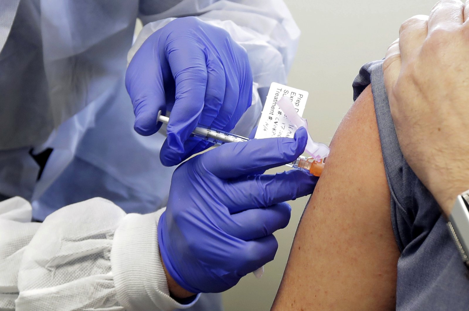 Neal Browning receives a shot in the first-stage safety study clinical trial of a potential vaccine for COVID-19, the disease caused by the new coronavirus, Monday, March 16, 2020, at the Kaiser Permanente Washington Health Research Institute in Seattle. (AP Photo)