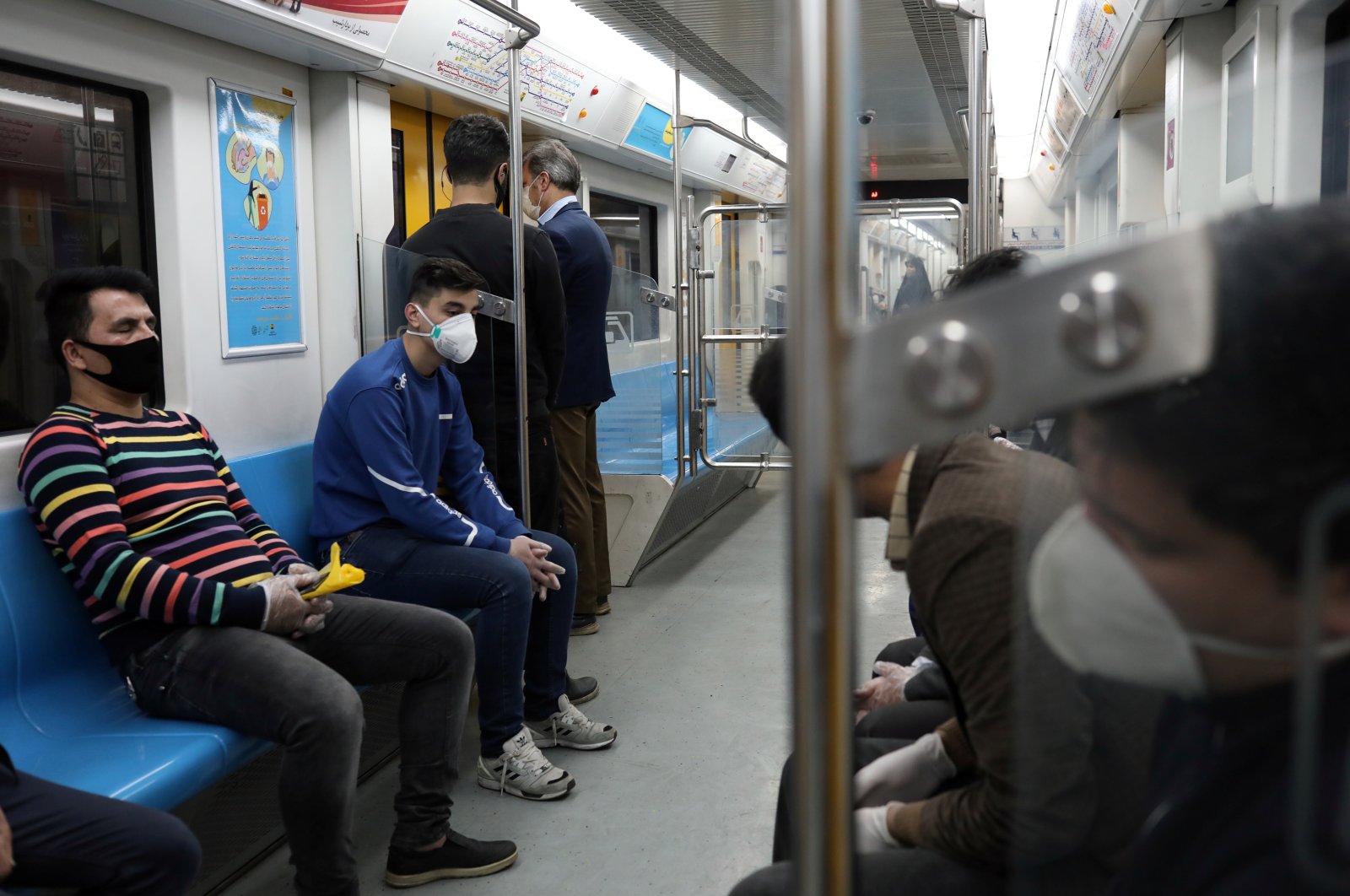 People wear protective face masks as they sit in a subway car in Tehran, Tuesday, March 17, 2020. (Reuters Photo)