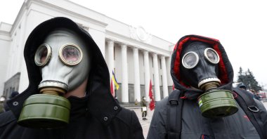 Activists wearing gas masks take part in a rally demanding to quarantine lawmakers amid coronavirus concerns, in front of the Ukrainian parliament building in Kiev, Ukraine March 17, 2020.  (REUTERS Photo)