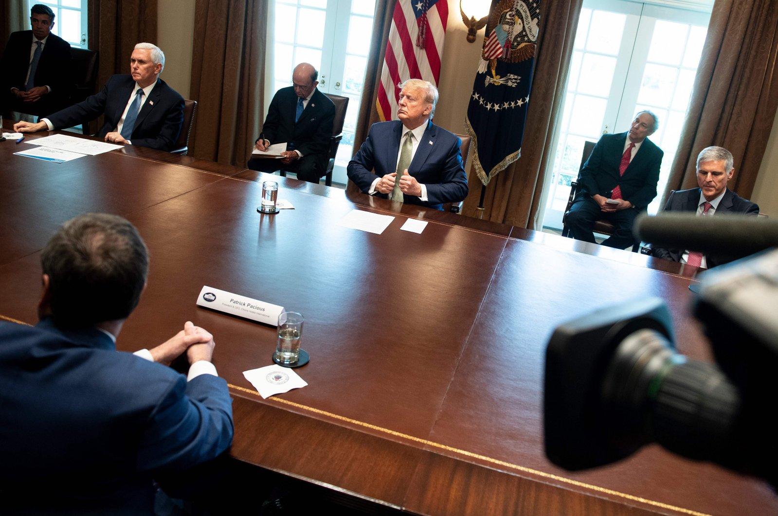 U.S. President Donald Trump and U.S. Vice President Mike Pence listen during a meeting with hotel and tourism executives in the Cabinet Room of the White House about the effect of the novel coronavirus epidemic, Tuesday, March 17, 2020. (AFP Photo)