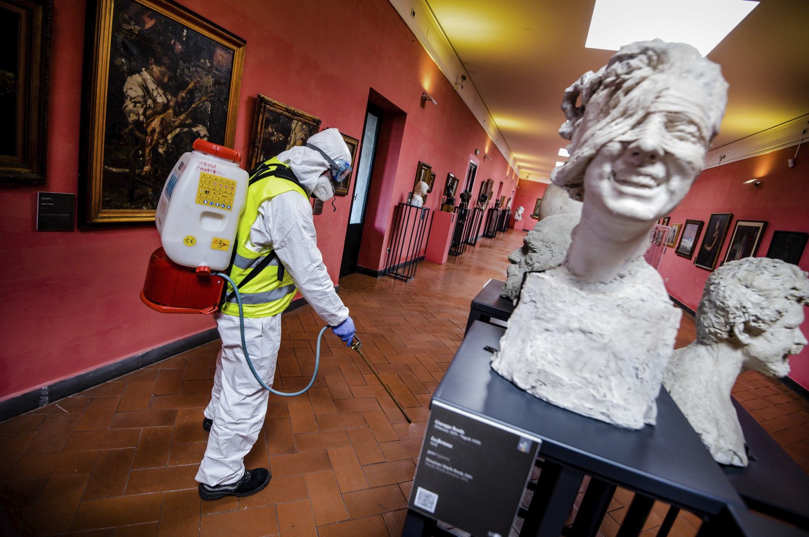 A worker sprays disinfectant to sanitize against coronavirus in the museum hosted by the Maschio Angioino medieval castle, in Naples, Italy, Tuesday, March 10, 2020. (LaPresse via AP)