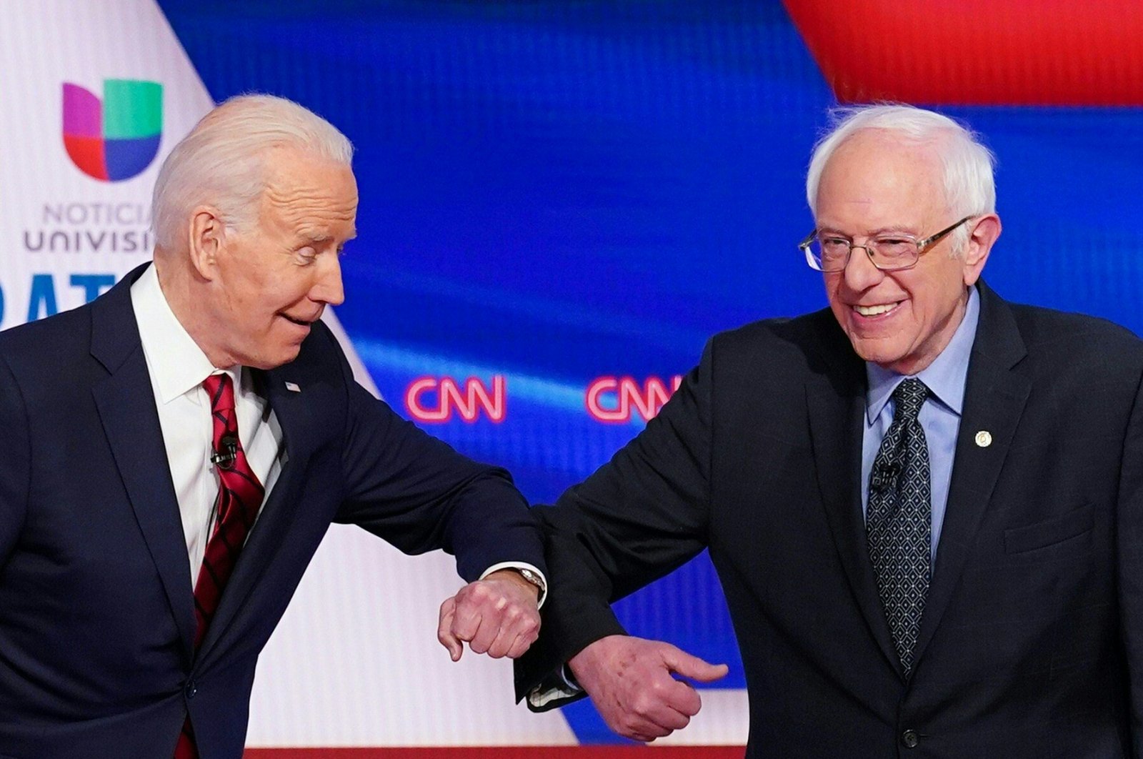 Democratic presidential hopefuls former U.S. Vice President Joe Biden (L) and Sen. Bernie Sanders (R) greet each other with an elbow bump, Washington, D.C., March 15, 2020. (AFP Photo)