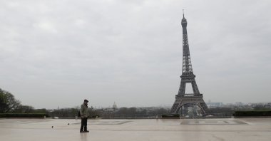 An elderly man walks by the Esplanade du Trocadero square near the Eiffel Tower in Paris, on March 18, 2020 in Paris as a strict lockdown comes into in effect in France to stop the spread of COVID-19, caused by the novel coronavirus. - (Photo by Ludovic Marin / AFP)
