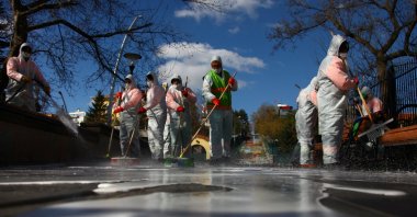 Municipality workers in protective suits disinfect Kuğulu Park due to coronavirus concerns, Ankara, Tuesday, March 17, 2020. (Reuters Photo)