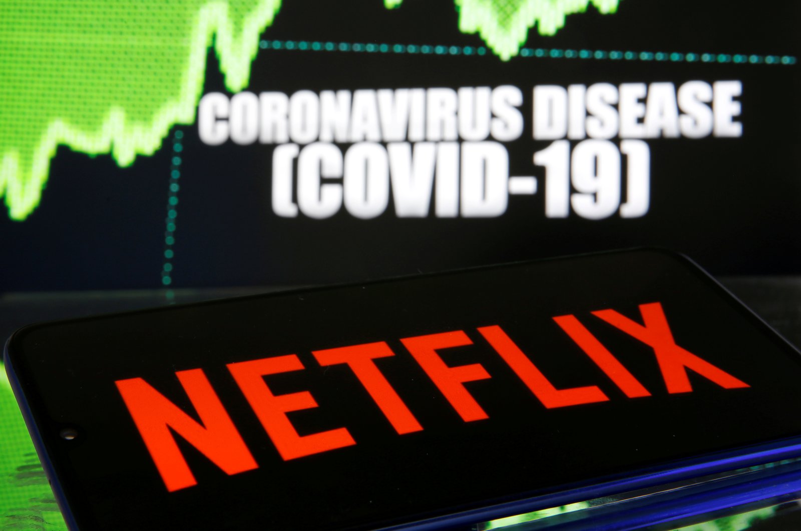 Netflix logo is seen in front of diplayed coronavirus disease (COVID-19) in this illustration taken March 19, 2020. (Reuters Photo)