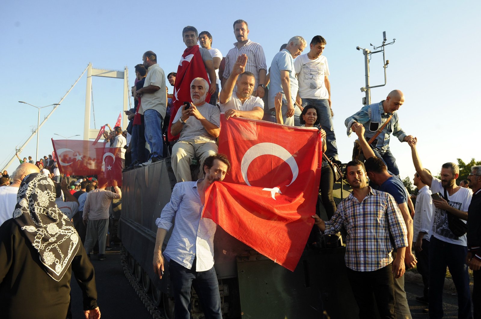 People pose with Turkish flag above an armored vehicle captured from putschists, Saturday, July 16, 2016, in Istanbul. (İHA Photo) 