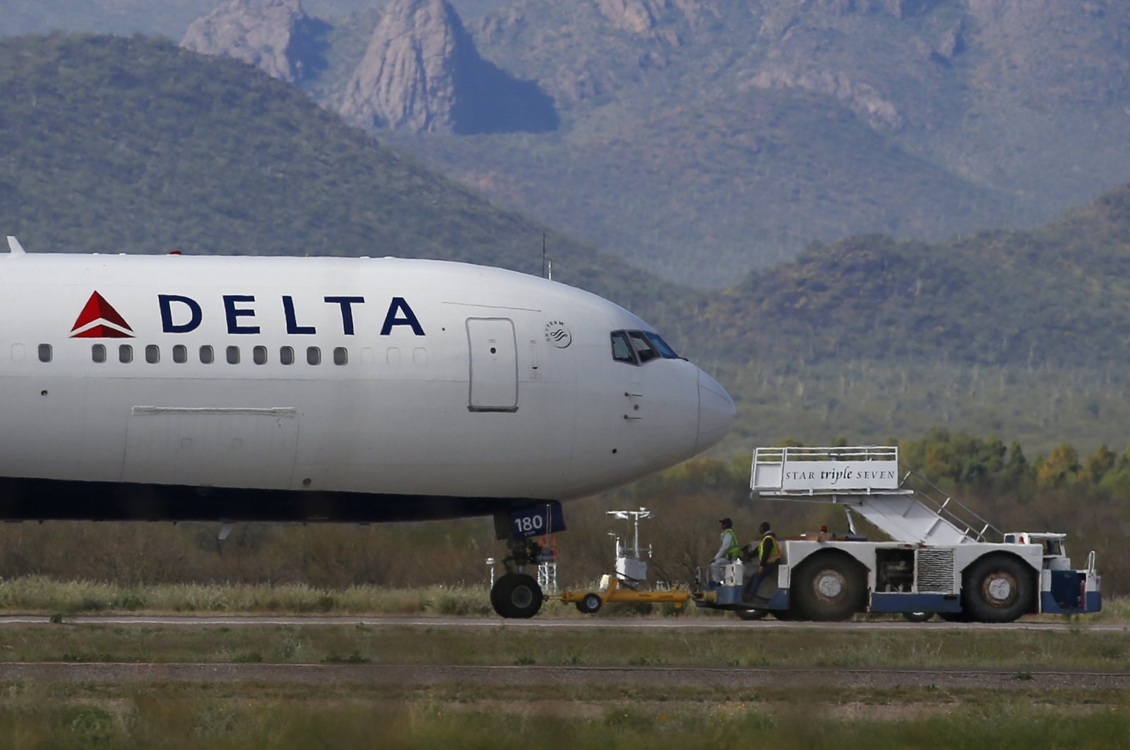 A recently landed Delta Air Lines airplane is worked on by ground crew at Pinal Airpark Wednesday, March 18, 2020. (AP Photo)