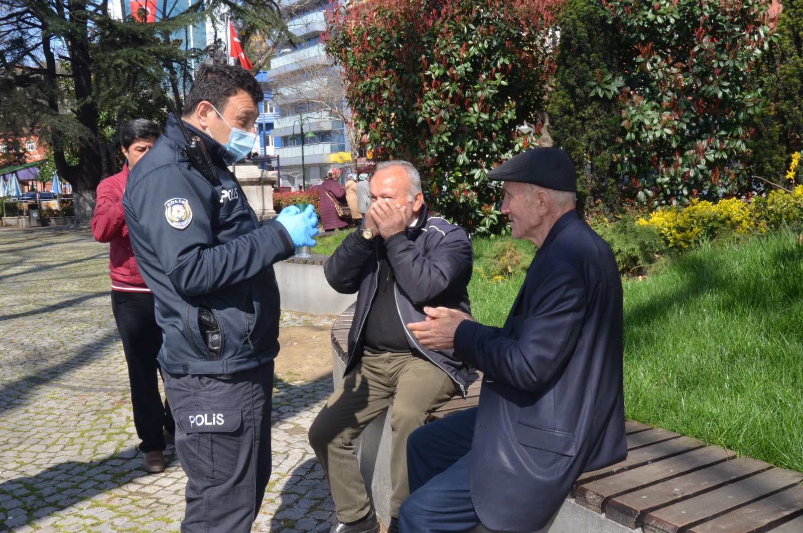 Police officer in Turkey's Zongulak offers elderly Turkish cologne and tells them that they are supposed to be at home, offers ride home, March 21, 2020. (IHA Photo)