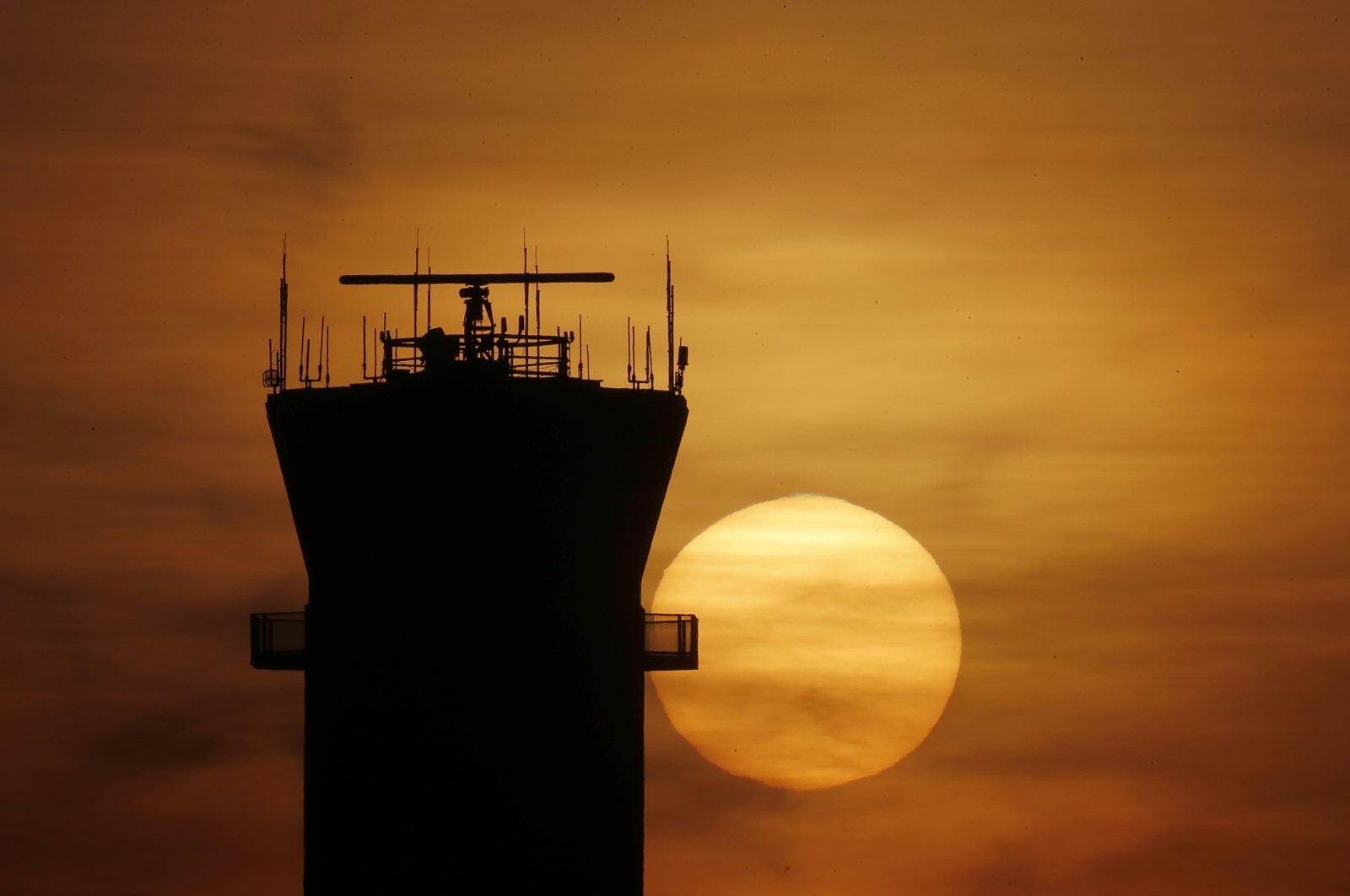 The sun sets behind the FAA Control Tower at Chicago's Midway International Airport on Tuesday, March 17, 2020, in Chicago. (AP Photo)