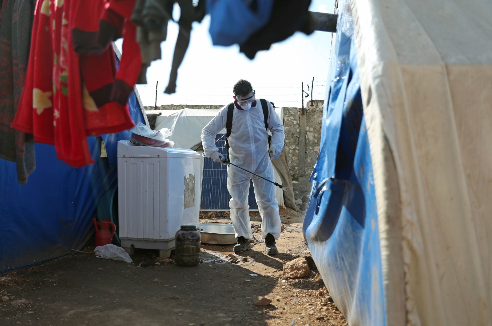 A member of the Syrian Violet NGO disinfects tents at a camp for displaced people in Kafr Jalis village, north of Idlib city, on March 21, 2020, as a preventive measure against the spread of the coronavirus. (AFP Photo)