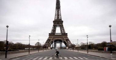 A man rides his bike on empty streets facing the Eiffel Tower, Paris, Saturday, March 21, 2020. (AFP Photo)